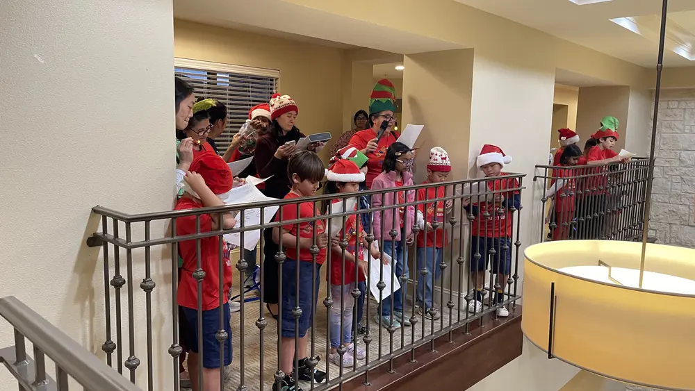 Scouts caroling from the balcony inside the senior living community