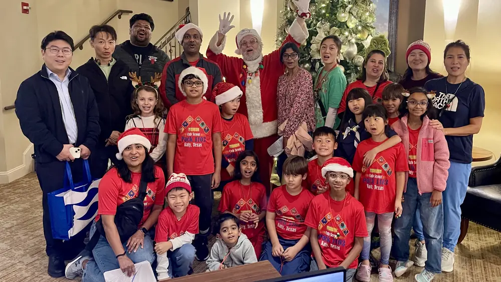 Scouts, parents, and Santa by the Christmas tree after caroling