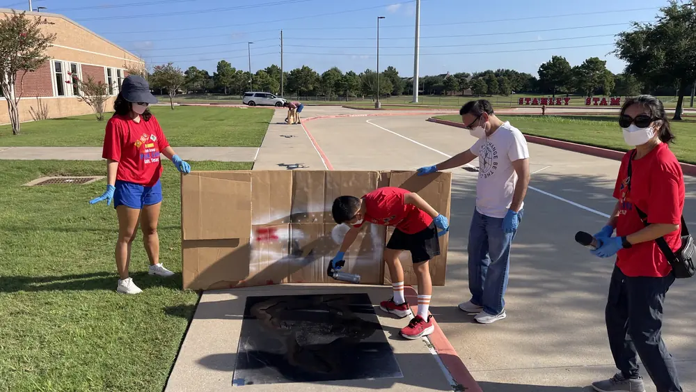 Pack 1103 scouts at the Stanley Elementary sign after the service project